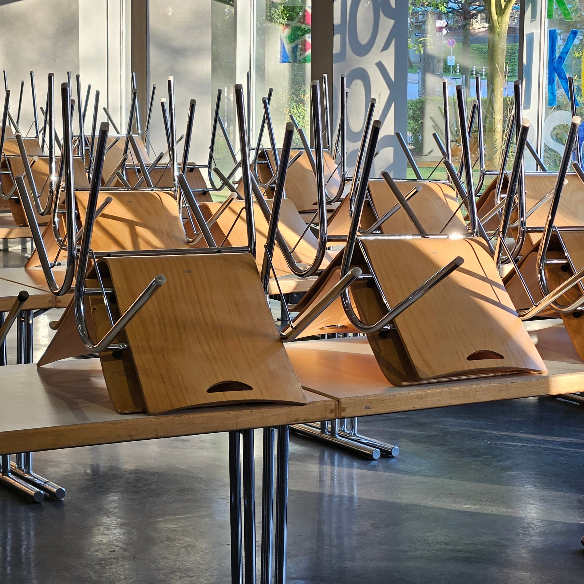 Nahaufnahme hochgestellter Holzstühle auf Tischen